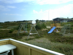 Aussicht von der Terrasse Richtung Spielplatz mit Spielplatz mit Kletterturm und Rutsche, Fuballtore und Baskettballkorb